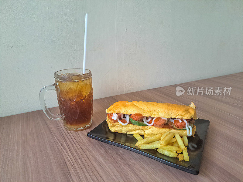 一份热狗薯条和冰鲜茶。热狗Kentang Goreng Dan Es Teh Segar。食物和饮料菜单。